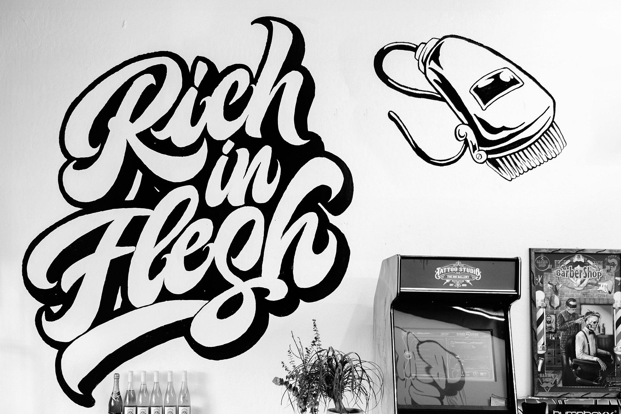 Rich in Flesh logo painted on the wall of the tattoo and barber shop in Livermore, CA